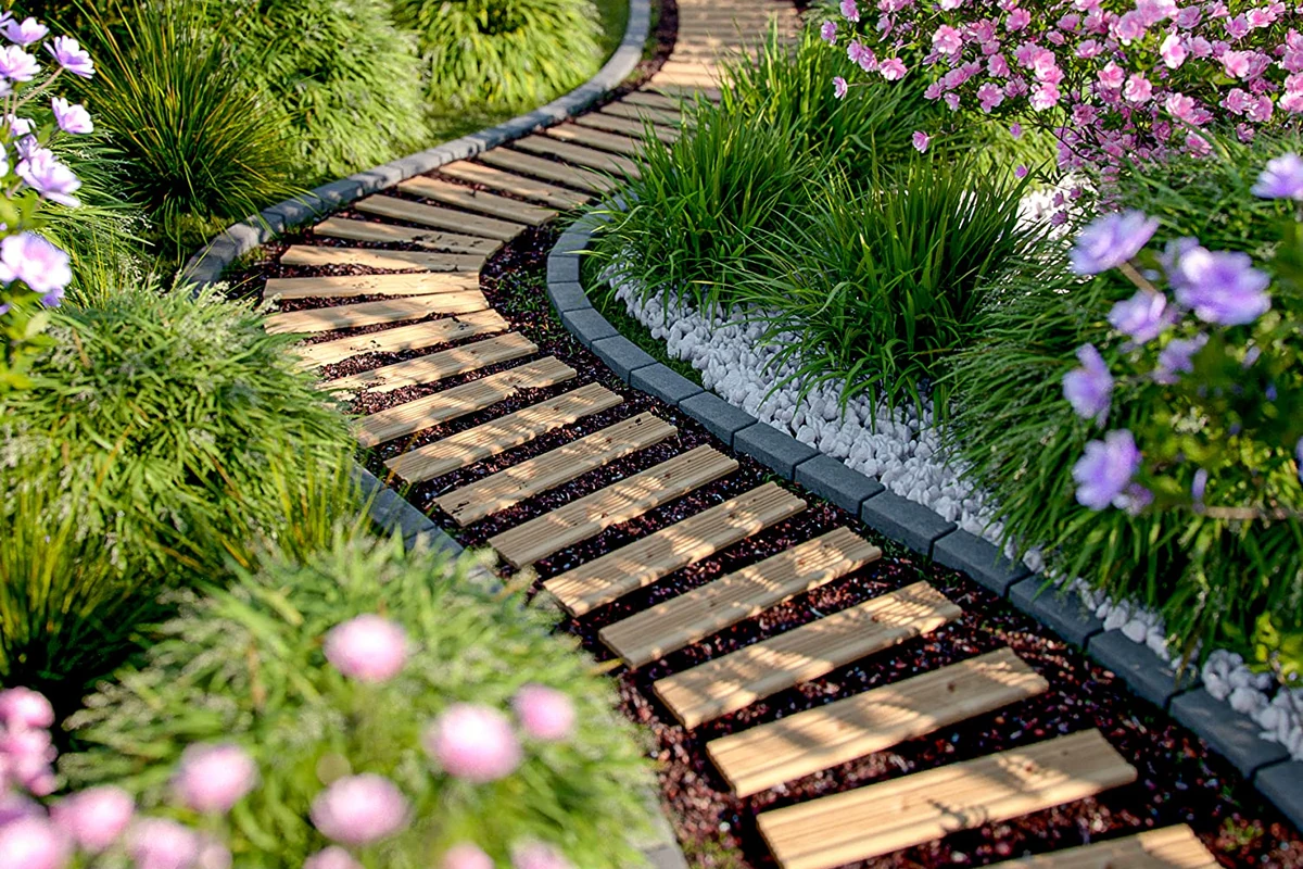 Natürlicher Gartenweg zwischen Grünpflanzen und Blumen